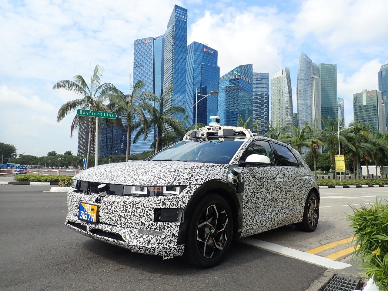 A Motional IONIQ 5 is shown driving with the downtown Singapore skyline in the background