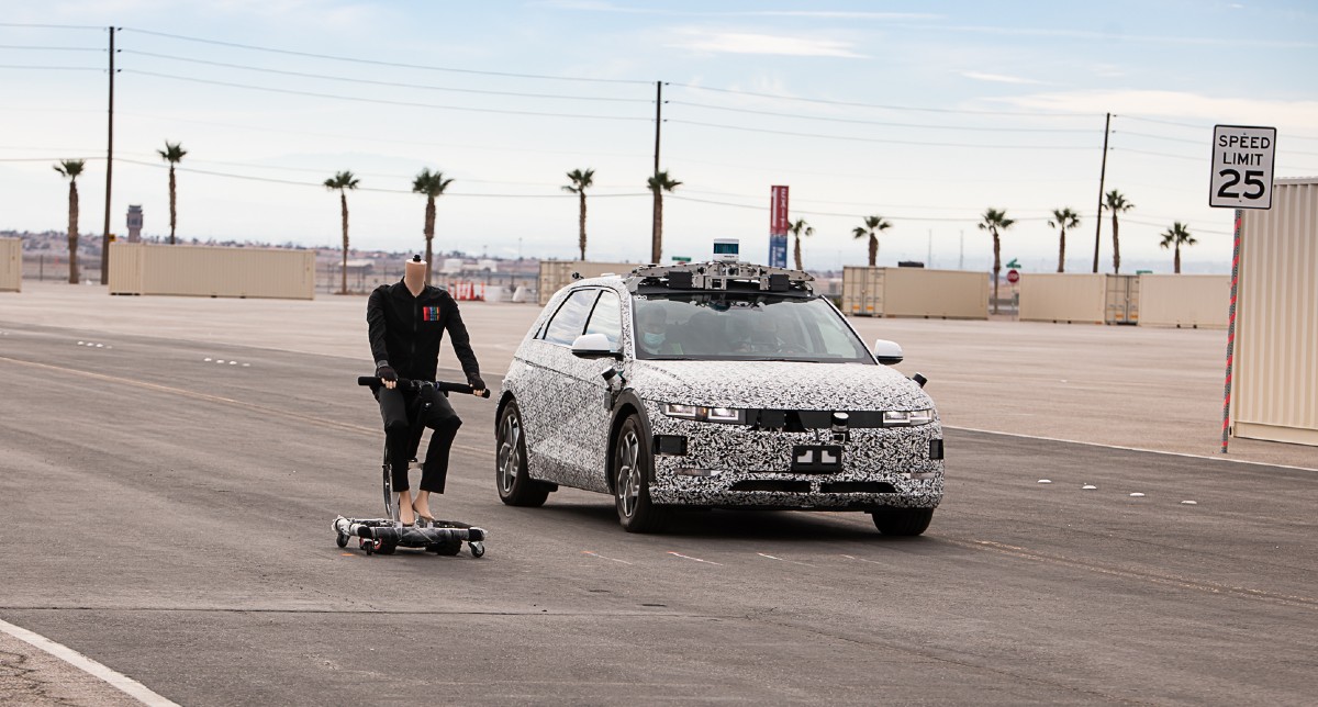 An IONIQ 5 robotaxi drives next to a dummy on a bicycle at Motional's Las Vegas test track