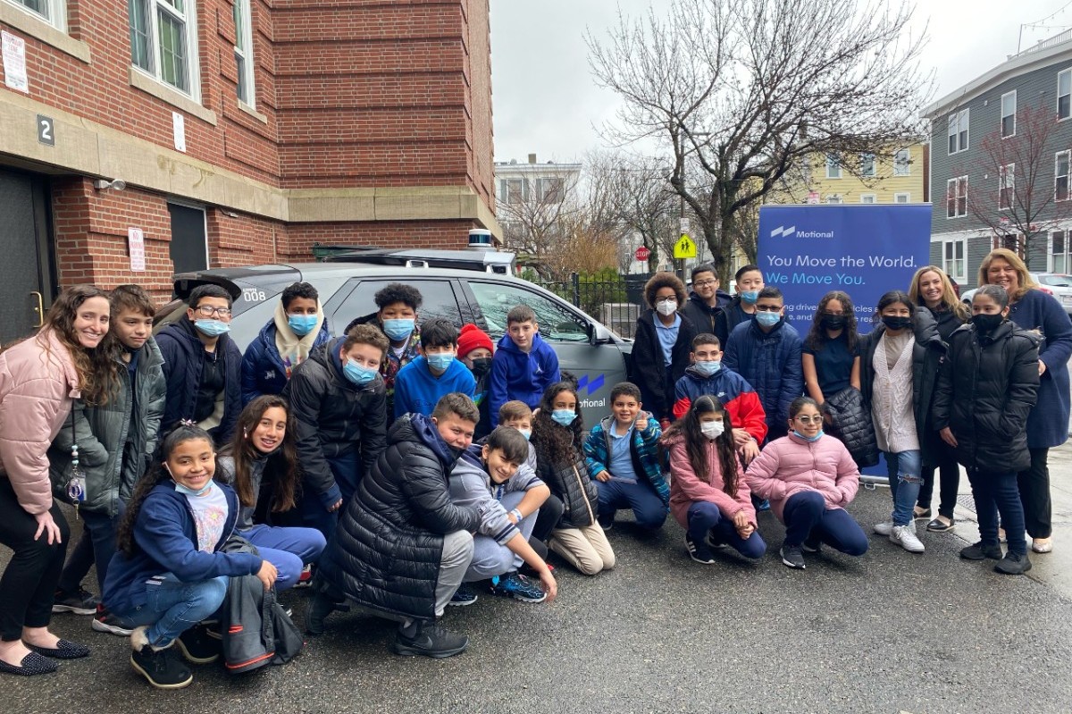 students and teachers from the Otis Elementary School in Boston pose in front of the IONIQ 5 robotaxi