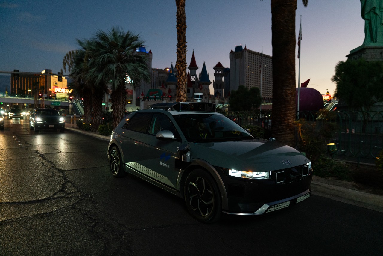A Motional IONIQ 5 robotaxi drives down The Strip in Las Vegas as night falls