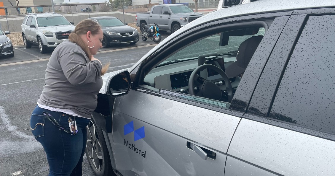 Candice Gallick, an AV performance analysis manager with Motional, checks over the exterior of a silver IONIQ 5 robotaxi before it heads out on the road in Las Vegas. 