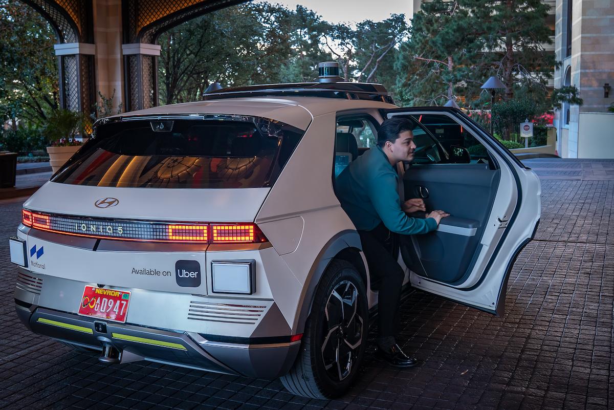 Person getting into a Motional and Uber robotaxi.